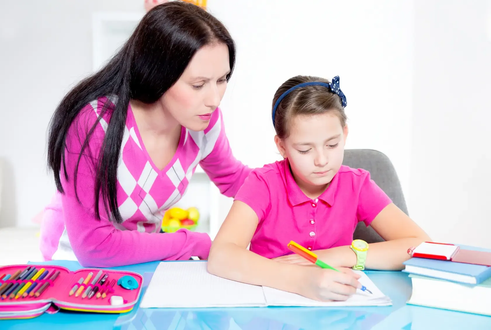 Professeur et élève travaillant à domicile pendant un stage de pré-rentrée, dans un cadre lumineux et rassurant